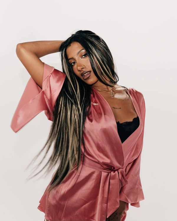 Black hair with bright blonde face-framing pieces and a pink silk robe